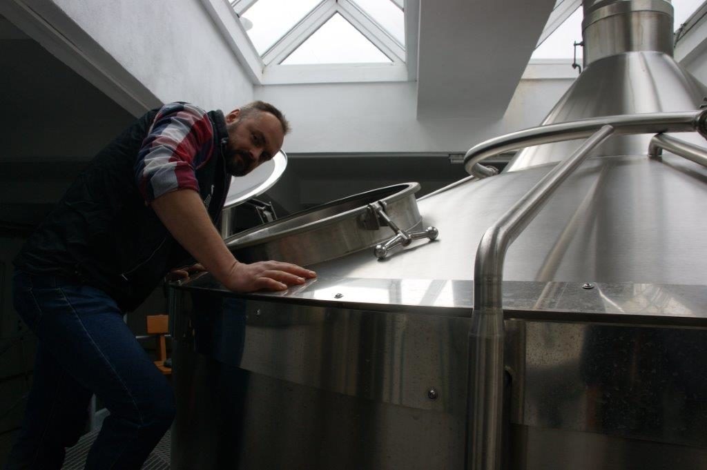 mężczyzna pochylony nad kadzią